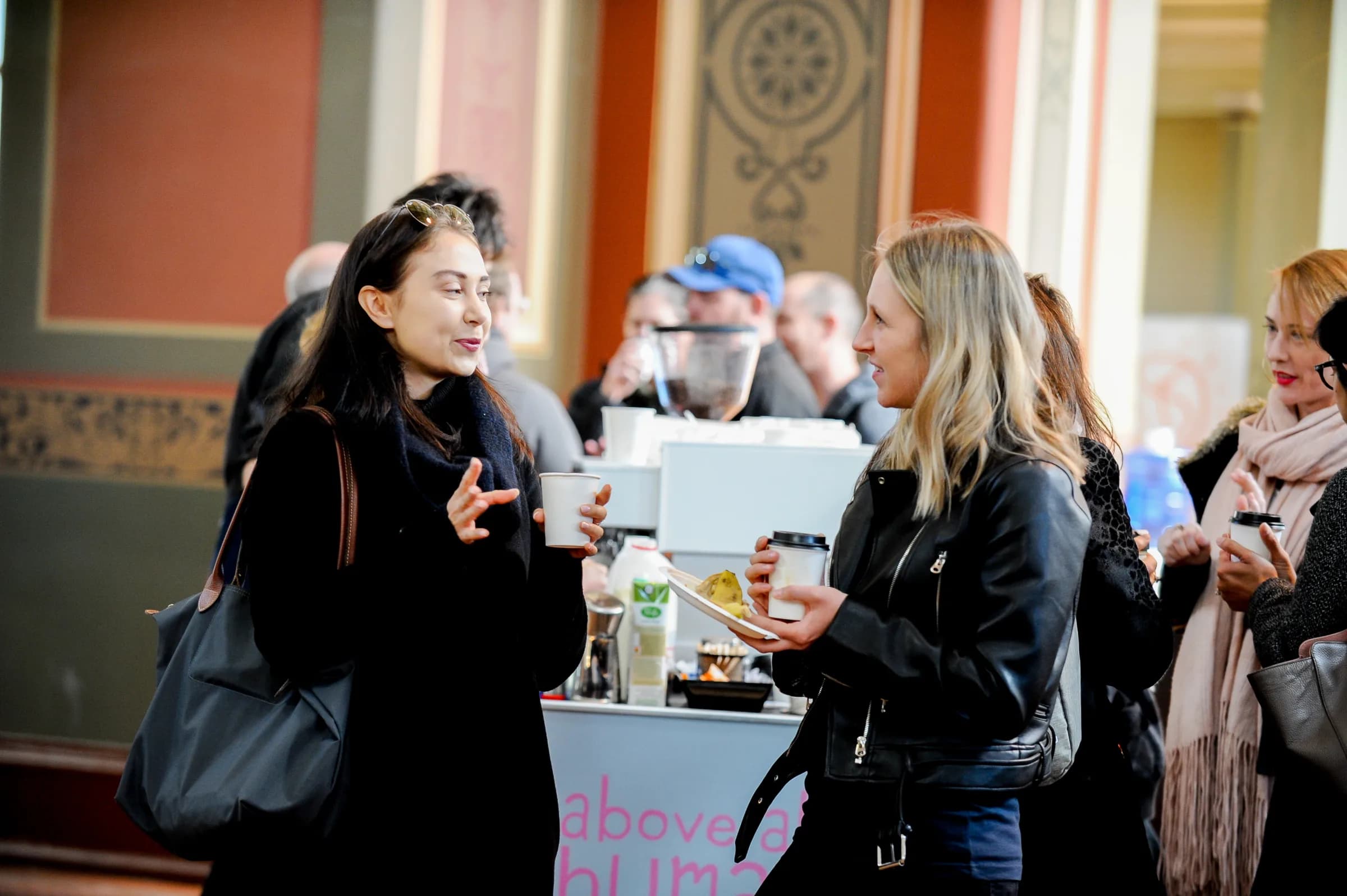 Conference delegates gathered around a branded Coffee on Cue cart, talking over coffee