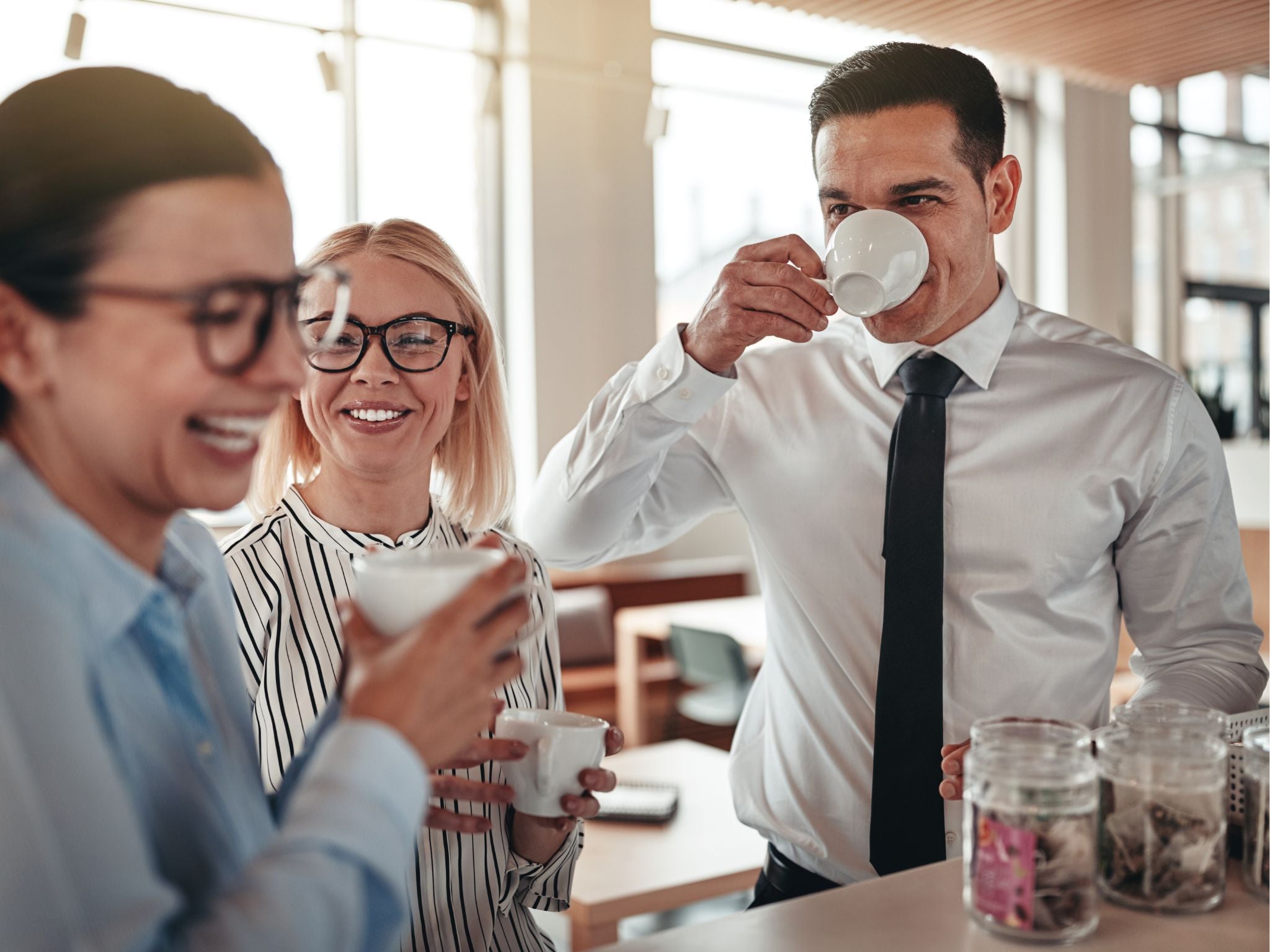 Co-workers drinking coffee together in the office