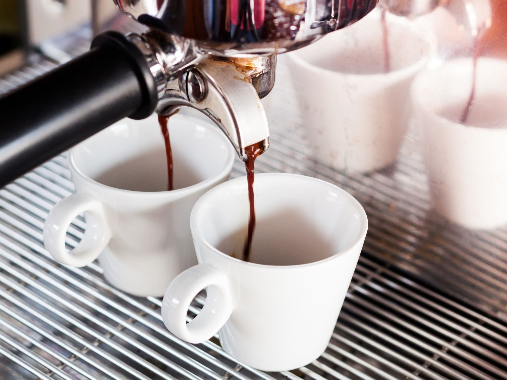 Espresso shots starting to drip into cups