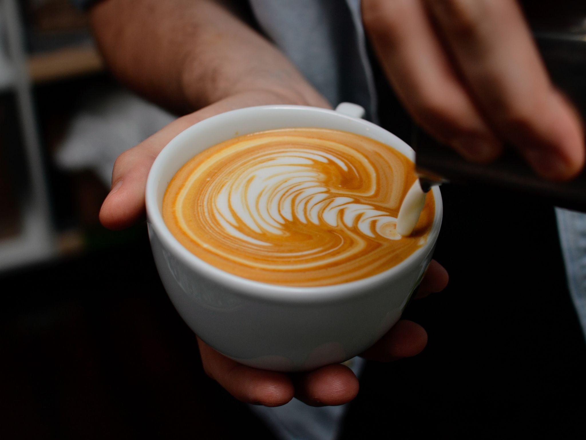 Rosette design being poured into latte