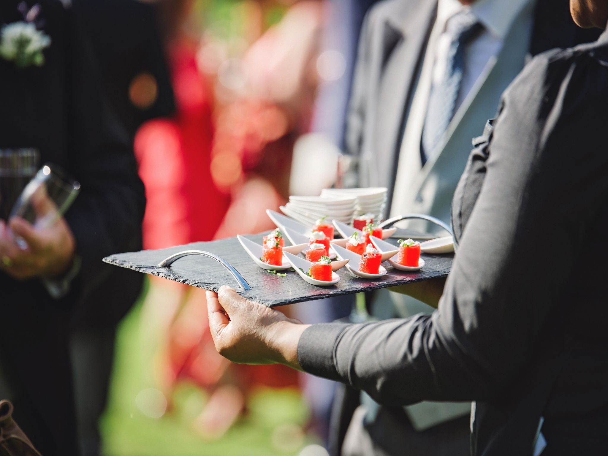 Staff member serving canapés from tray