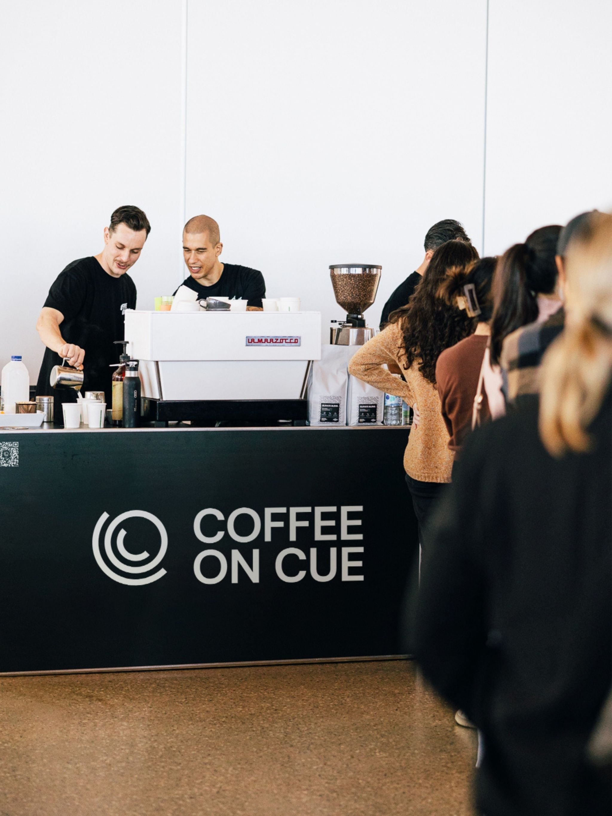 Baristas serving a line of customers