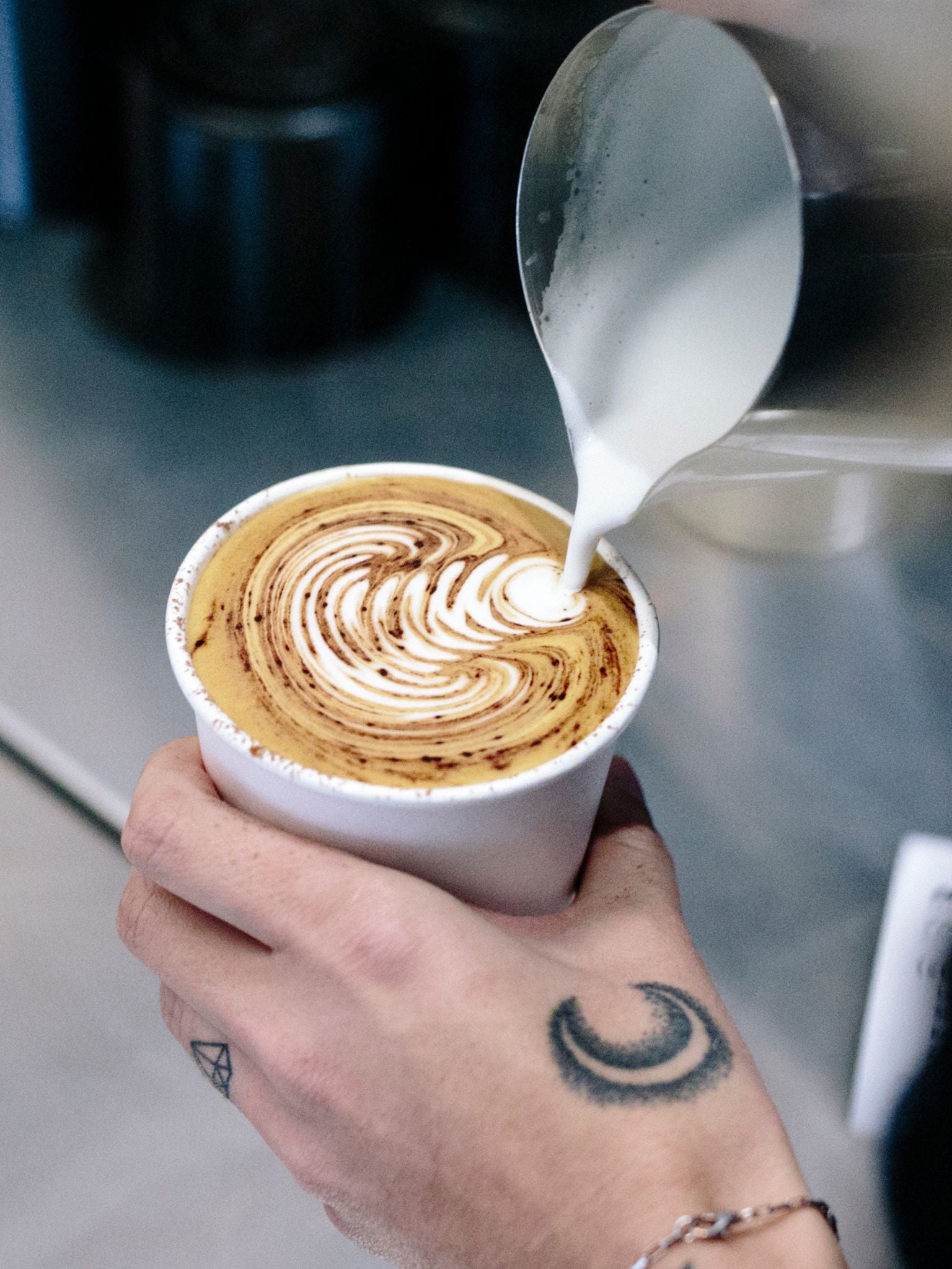 Latte art poured into takeaway cup