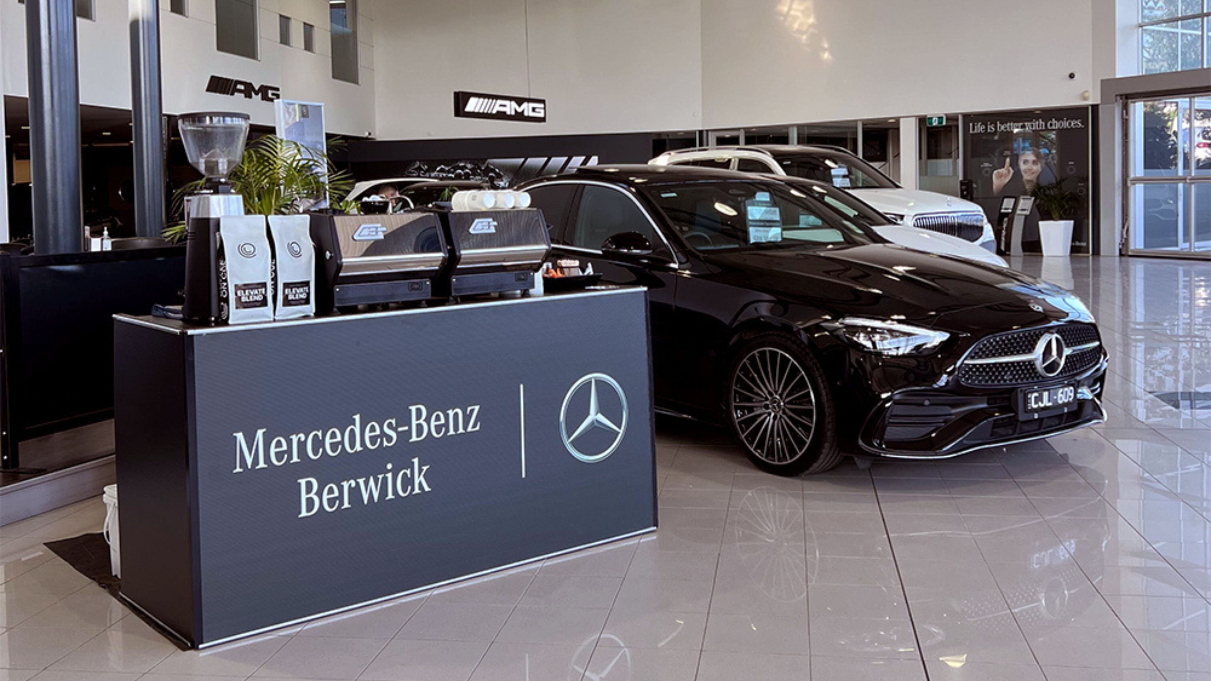 Mercedes Benz branded coffee cart next to car