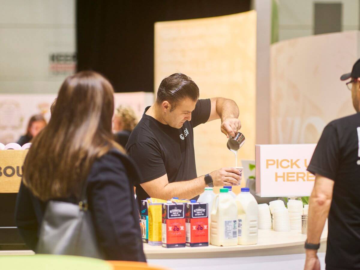 Tradeshow barista pouring milk coffee