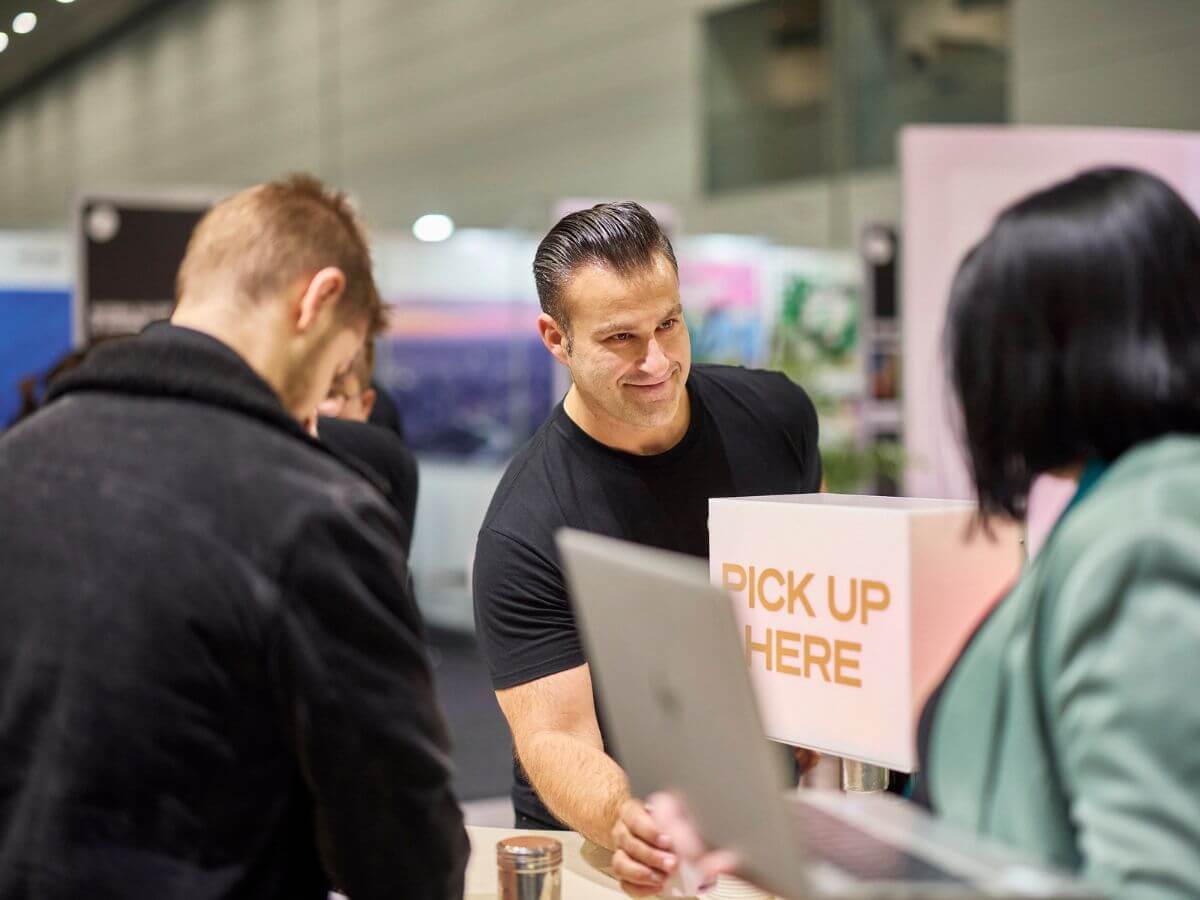 Barista serving coffee at Visit Victoria tradestand