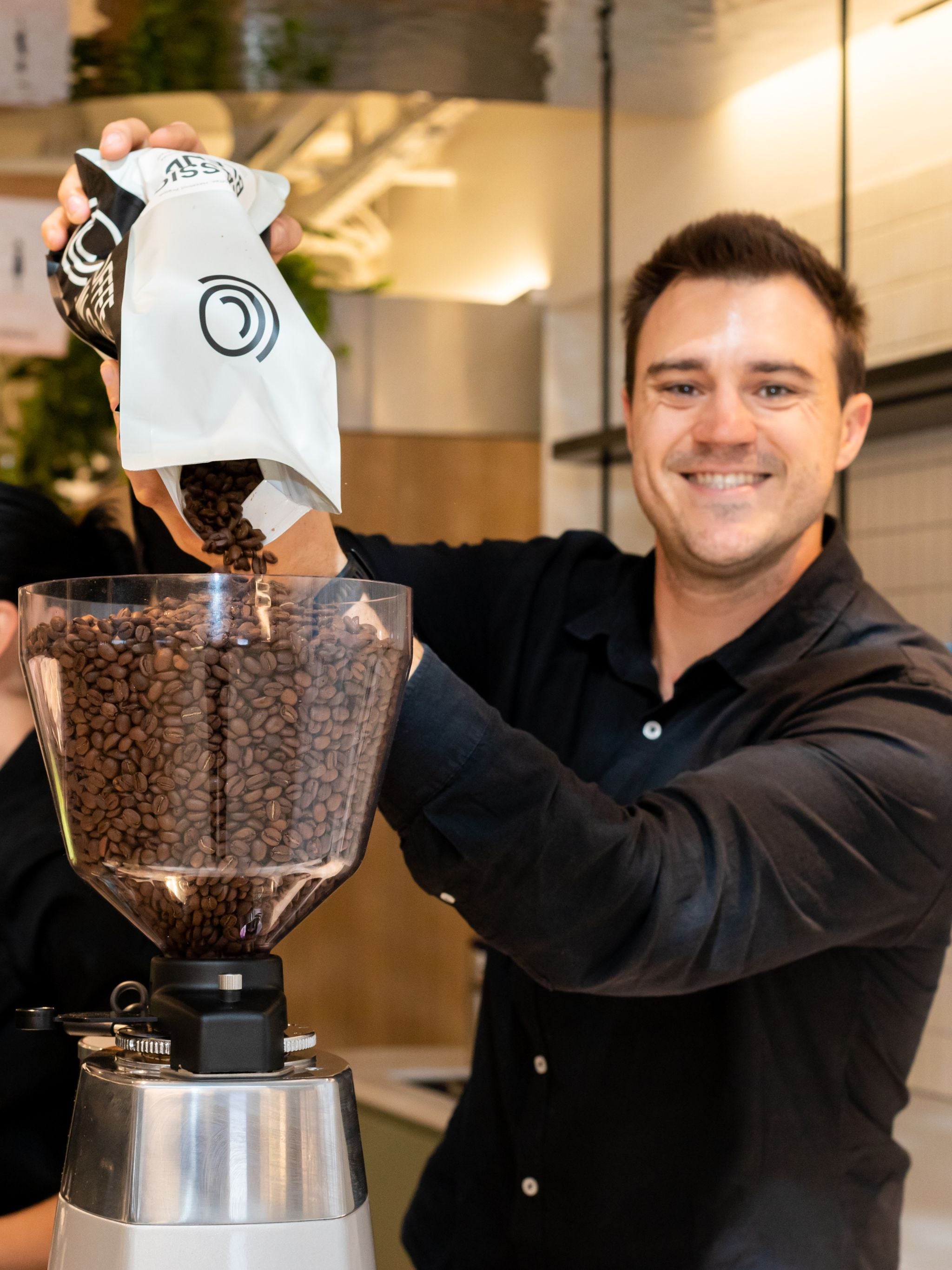 Barista filling up grinder hopper