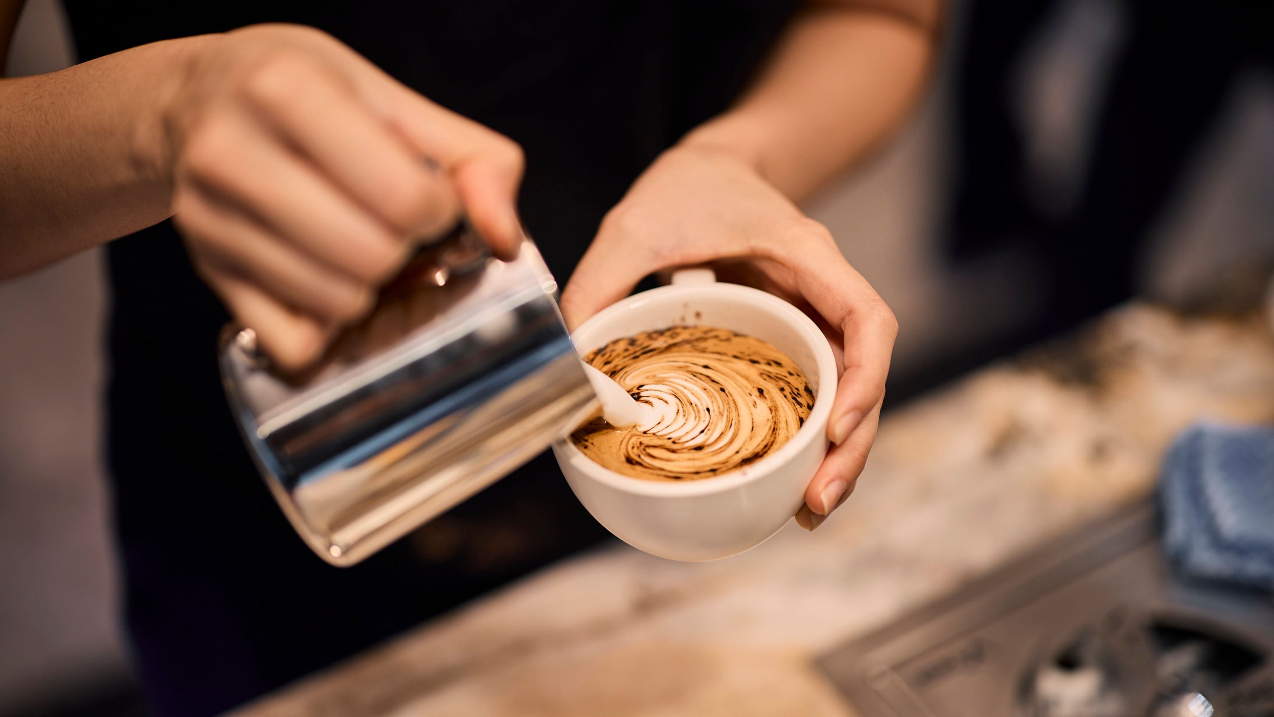 Coffee art being poured into cup