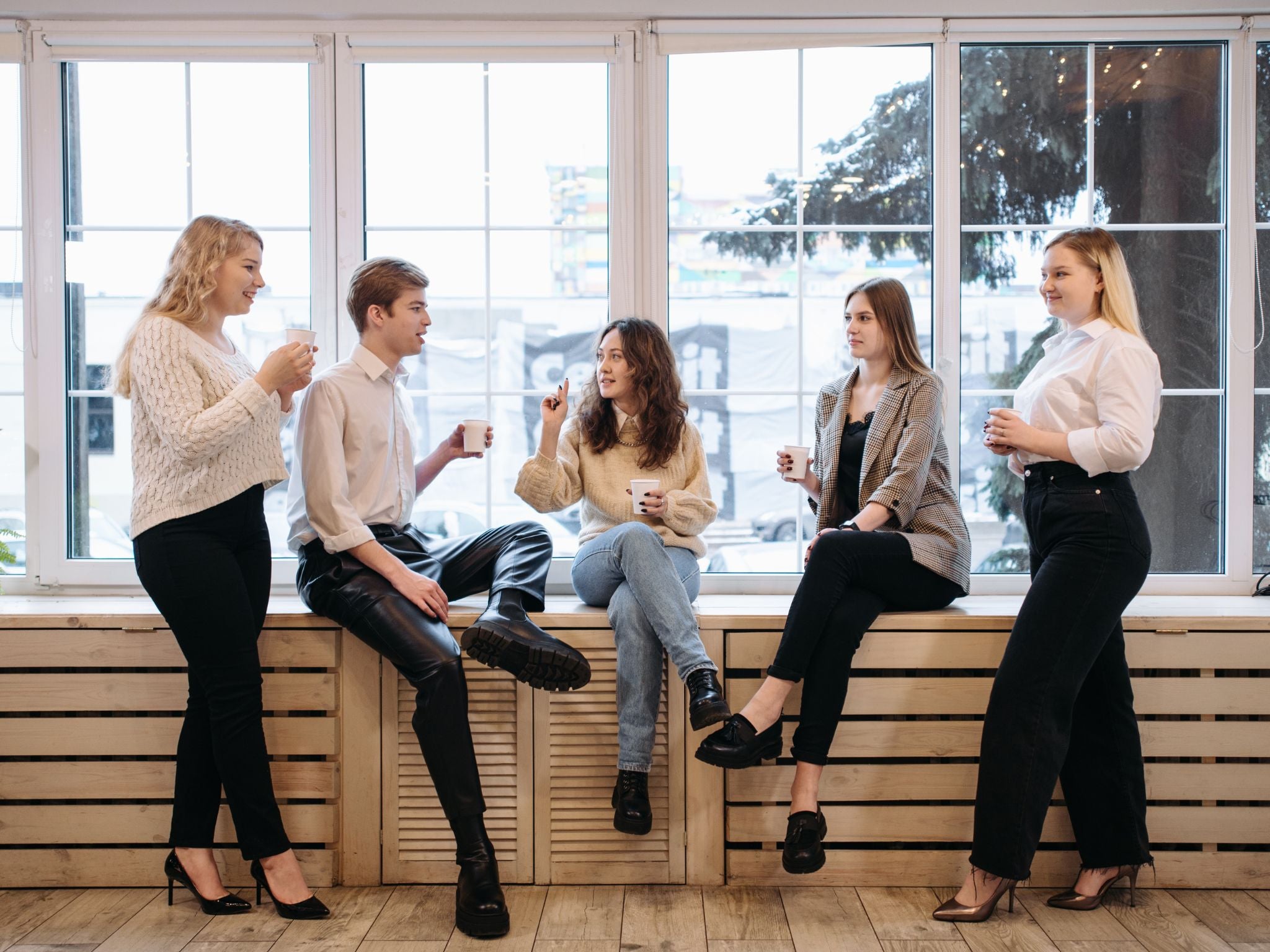 Workplace employees mingling in the office with coffee