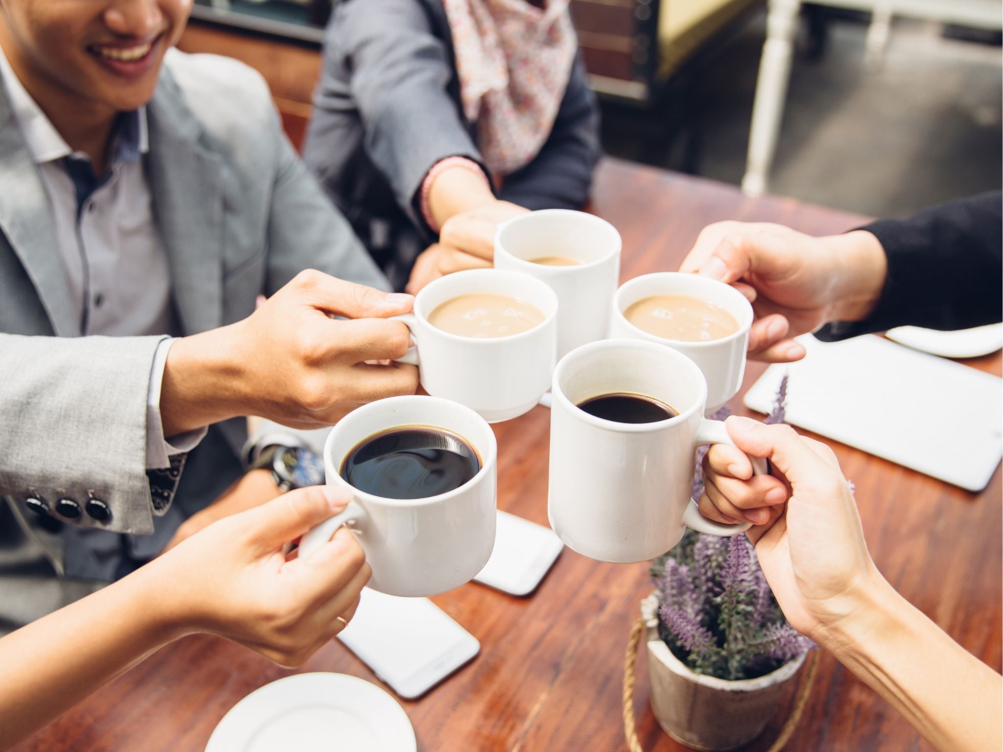 Office team cheering their coffees together